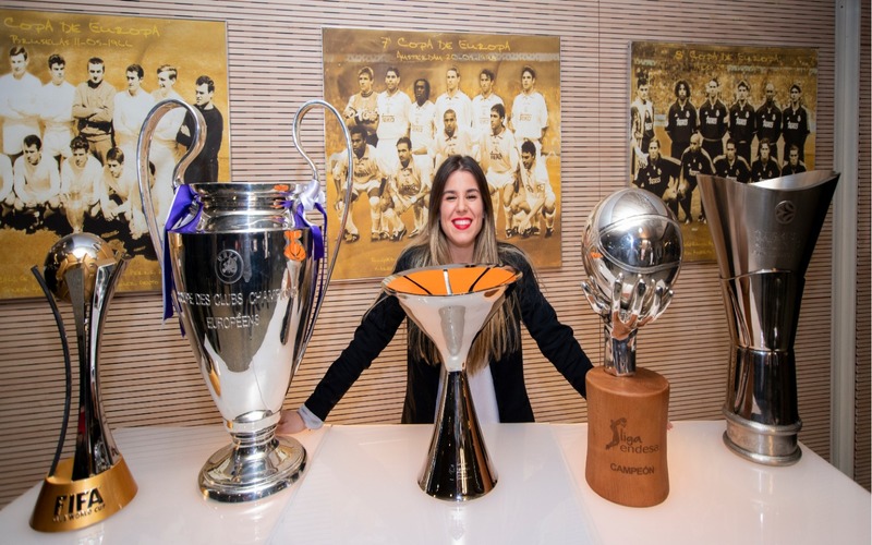 Paula Naveira posando con las copas conseguidas por el Real Madrid a lo largo del año 2018. 